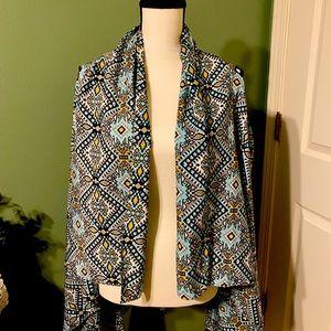 Vest is made with Native American design material. Is worn over shirt.